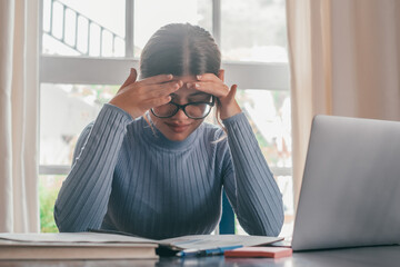 Wall Mural - Tired bored teenage girl school student feeling headache or fatigue doing homework at home. Exhausted depressed sick teenager studying alone worried about difficult education problems concept..