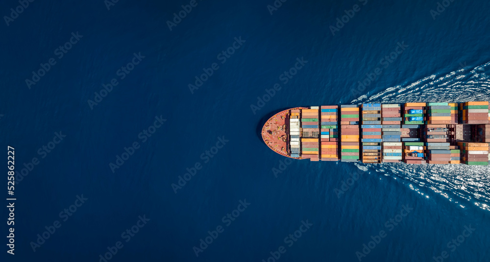 Aerial top down view of a large container cargo ship in motion over open ocean with copy space