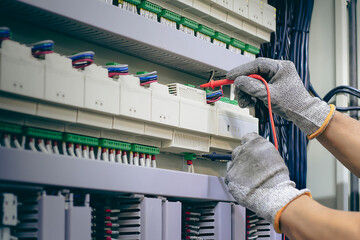 Wall Mural - Technician checking the operation of electrical control equipment.