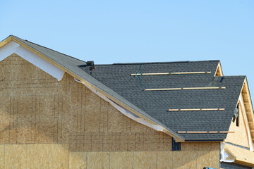 Wall Mural - edge of roof shingles on top of the house, dark asphalt tiles on the roof