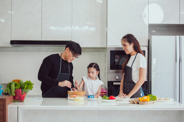 Asian family cooking at home. Happy family cooks together in the kitchen home recreation and weekend meal prep.