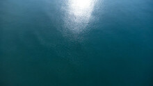 Aerial View From The Drone Of The Sea. Background Image Of Sea Surface With Sunlight Reflecting On Water Surface. Blue Sea Background In Tropical Sea
