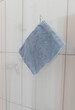 a blue washcloth is hanging in a bathroom on a glass door
