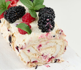 Canvas Print - Baked meringue roll with cream and fresh fruits on a white wooden board, delicious dessert