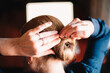 © Cavan Images - Close up of mature woman making hair bun at home