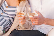 Glasses With Wine In Hands With Wedding Rings Of Young Couple In