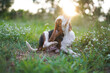 Beagle dog scratching body outdoor on the grass field.
