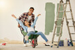 © Anela Ramba/peopleimages.com - Love, teamwork and renovation, couple paint a wall in a house green. Happy, creative and playful, new home owners do repair work on home. Wheelbarrow, ladder and painting, man and woman have diy fun