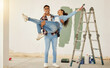Diy, home improvement and wall painting with happy couple renovating house and having fun together. Playful husband and wife being silly and goofy, enjoying their relationship and project together