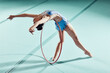 © C Coetzee/peopleimages.com - Sports woman, performance and balance ring for gymnastics show. Fitness girl doing artistic pose and stretch for acrobat stunt. Young and beautiful athlete in gym with hula hoop and flexible body.