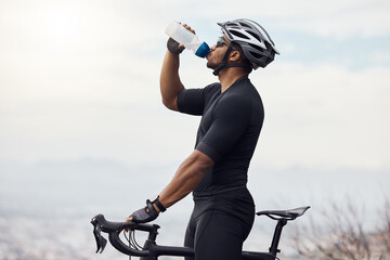 Canvas Print - Sports man with a bike drinking water bottle doing fitness training or workout on sky mockup background. Healthy, professional athlete cyclist with a bicycle during cycling cardio exercise in nature