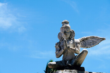 Statue of angel against blue sky