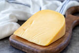 Fototapeta  - Yellow gouda cheese. Hard Dutch gouda cheese, on dark background. close up