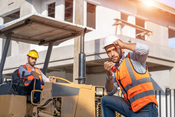 Poster - Engineer holding Walkie-Talkie are working at construction site and wearing hardhat.