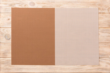 Wall Mural - Top view of brown tablecloth for food on wooden background. Empty space for your design