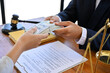 © bongkarn - A female client in the office with her lawyer, giving bribes to her lawyer to win the lawsuit.