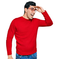 Wall Mural - Handsome hispanic man wearing casual clothes and glasses very happy and smiling looking far away with hand over head. searching concept.