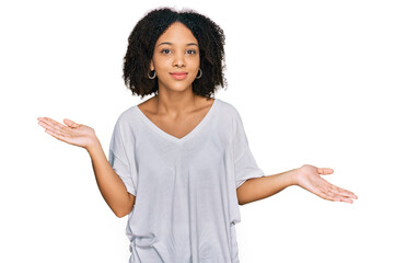 Wall Mural - Young african american girl wearing casual clothes clueless and confused expression with arms and hands raised. doubt concept.