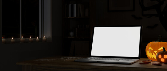 Modern dark office room at night in Halloween theme with laptop mockup and Halloween pumpkin lamp