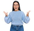 © Krakenimages.com - Young hispanic woman wearing casual clothes and glasses celebrating crazy and amazed for success with arms raised and open eyes screaming excited. winner concept