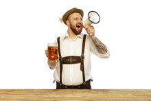 Portrait Of Young Man Wearing Traditional Bavarian Or German Clothes Shouting In Megaphone And Inviting To Beer Party Isolated Over White Background
