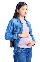 Sticker - Young beautiful chinese woman pregnant expecting baby looking sleepy and tired, exhausted for fatigue and hangover, lazy eyes in the morning.