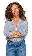 © Krakenimages.com - Middle age hispanic woman wearing casual clothes happy face smiling with crossed arms looking at the camera. positive person.