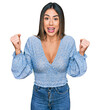 © Krakenimages.com - Young hispanic woman wearing casual clothes celebrating surprised and amazed for success with arms raised and open eyes. winner concept.