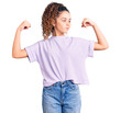 © Krakenimages.com - Beautiful kid girl with curly hair wearing casual clothes showing arms muscles smiling proud. fitness concept.