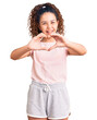 © Krakenimages.com - Beautiful kid girl with curly hair wearing casual clothes smiling in love doing heart symbol shape with hands. romantic concept.