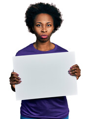 Wall Mural - African american woman with afro hair holding blank empty banner skeptic and nervous, frowning upset because of problem. negative person.