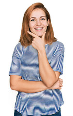 Wall Mural - Young caucasian woman wearing casual clothes looking confident at the camera smiling with crossed arms and hand raised on chin. thinking positive.