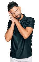 Poster - Young man with beard wearing sportswear sleeping tired dreaming and posing with hands together while smiling with closed eyes.