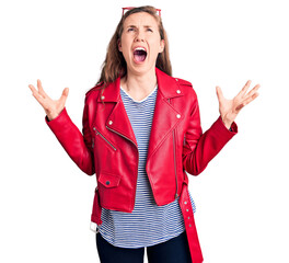 Canvas Print - Young beautiful blonde woman wearing casual leather jacket crazy and mad shouting and yelling with aggressive expression and arms raised. frustration concept.