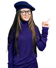 Canvas Print - Young brunette girl with long hair wearing french look with beret and glasses smiling happy pointing with hand and finger to the side