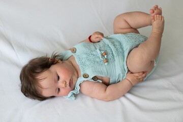 Close-up shot of a cute baby toddler on a white fabric