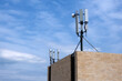 Cell phone antenna tower on the roof of the building. Copy space. 
