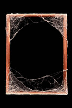 Old Frightening Wooden Photo Frame Entwined With White Cobwebs On All Sides Isolated On A Black Background,