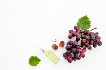 Grape seed essential oil with bunch of grapes. Eco cosmetic product