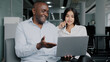 © Yuliia - Diverse colleagues two business partners african arabian co-workers discuss internet project on laptop at office meeting planning working main tasks partnership cooperation managing corporate teamwork