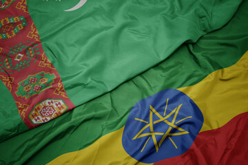 waving colorful flag of ethiopia and national flag of turkmenistan.