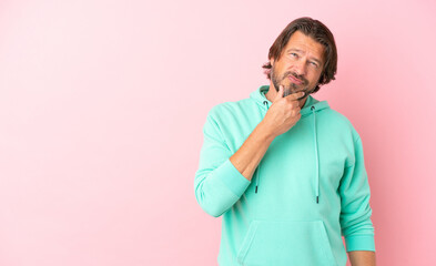 Wall Mural - Senior dutch man isolated on pink background thinking