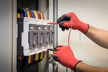 Wall Mural - Technician checking the operation of electrical control equipment.