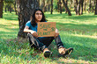 © Fabián Montaño - Ethnic teenage with Save The Planet inscription on cardboard piece in the forest