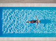 © Cavan Images - Female Swimming On Inflatable In Pool