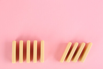 Wall Mural - White domino tiles on pink background, flat lay. Space for text