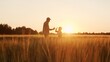 © Acronym - Farmer and his son in front of a sunset agricultural landscape. Man and a boy in a countryside field. Fatherhood, country life, farming and country lifestyle.