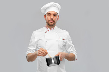 cooking, culinary and people concept - male chef in toque with pot or saucepan over grey background