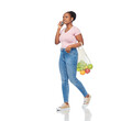 © Syda Productions - sustainability, food shopping and eco friendly concept - happy african american woman calling on smartphone and holding reusable string bag with fruits and vegetables walking over white background