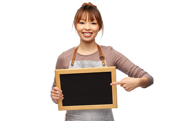 Wall Mural - cooking, culinary and people concept - happy smiling female chef or waitress in apron with chalkboard over white background